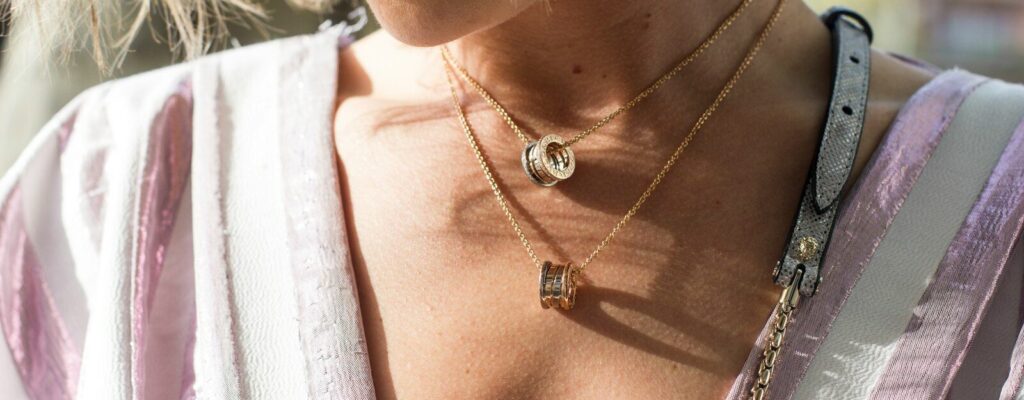 woman wearing gold-colored ring pendant necklaces